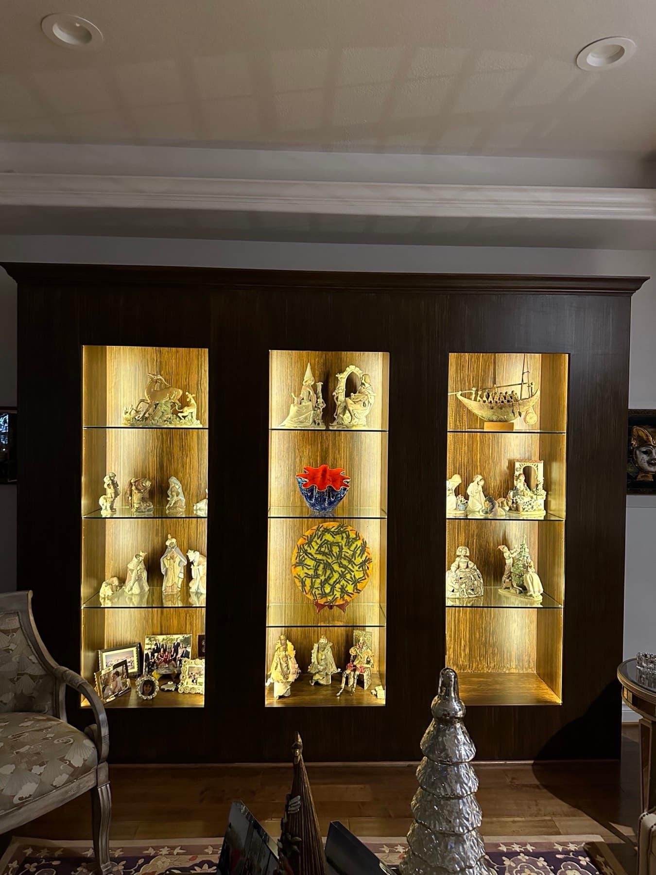 Dark wood display cabinet with warm backlit glass shelves