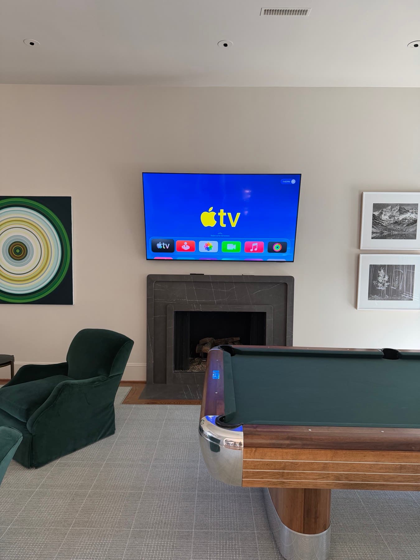 Samsung television mounted above the fireplace beside a billiards table in a River Oaks media room
