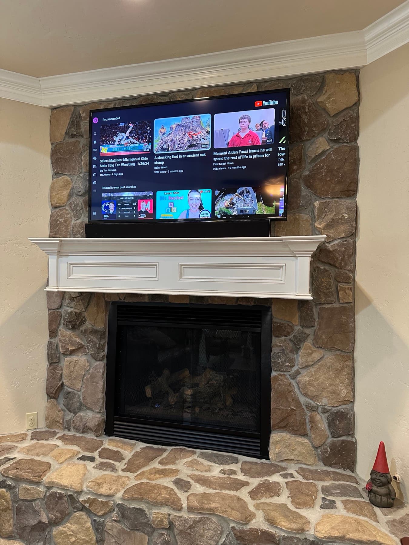 Flat-panel television mounted above a floor-to-ceiling stone fireplace