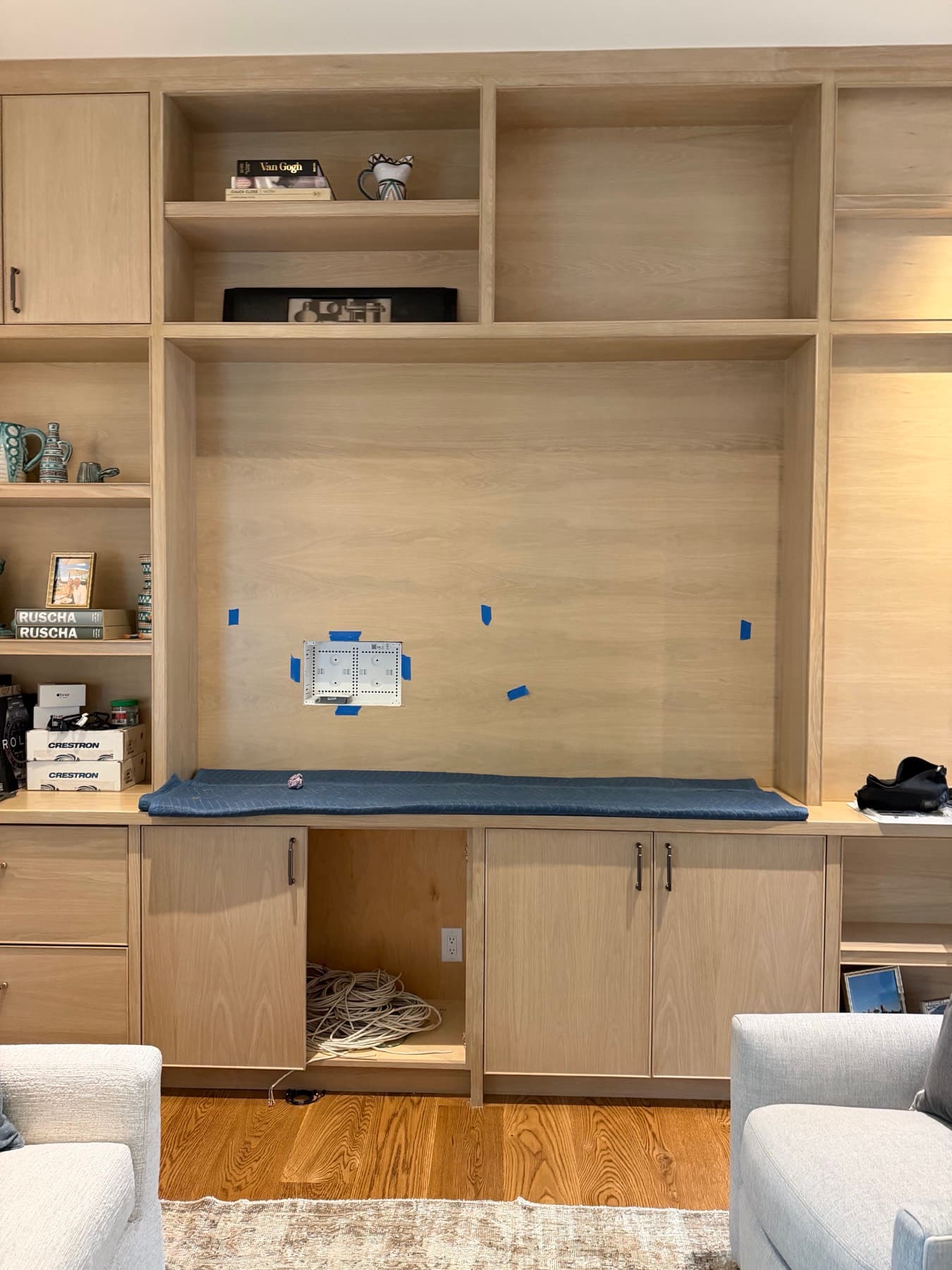 Empty custom millwork built-in with painter's tape and loose cables before a Frame TV install