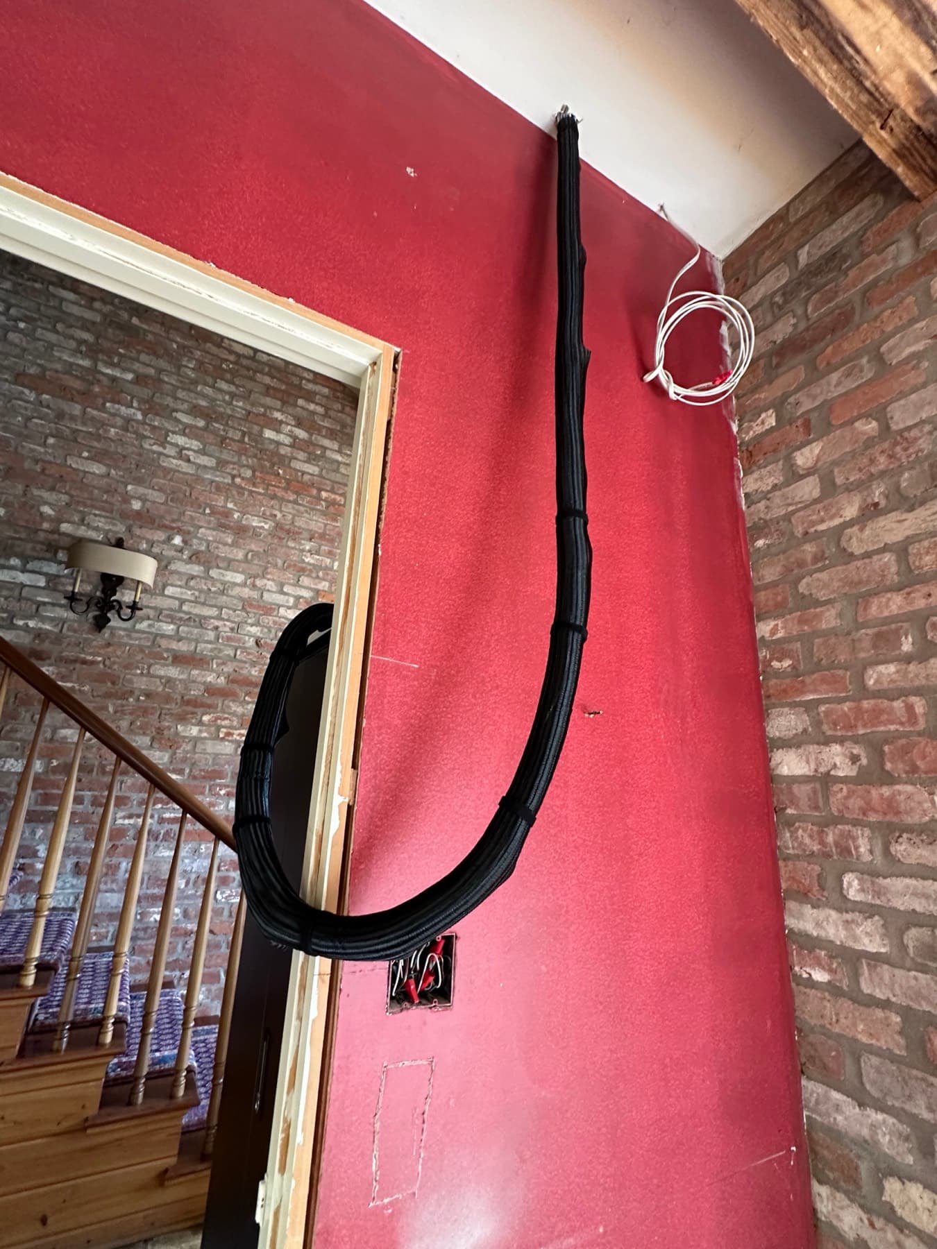 Low-voltage wiring neatly bundled and concealed in conduit after repair